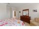 Bedroom with floral bedding, wood dresser and neutral paint, and tile flooring at 9761 Sw 74Th Pl, Ocala, FL 34481