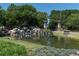 Stone Creek entrance featuring a lovely waterfall, pond, manicured landscaping, and decorative entry towers at 9761 Sw 74Th Pl, Ocala, FL 34481