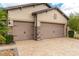 Attached two-car garage showcasing stone accents and a spacious paver driveway at 9761 Sw 74Th Pl, Ocala, FL 34481