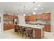 Kitchen with island and seating, pendant lights, granite counters and wooden cabinets at 9761 Sw 74Th Pl, Ocala, FL 34481