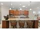 Close-up view of the kitchen island featuring granite countertops, wooden cabinets, and bar stool seating at 9761 Sw 74Th Pl, Ocala, FL 34481