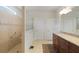 Bathroom featuring a tiled shower, a vanity with granite countertops, and neutral colored tile flooring at 9761 Sw 74Th Pl, Ocala, FL 34481