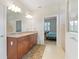 Bathroom featuring a double sink vanity with granite countertops and views of the main bedroom at 9761 Sw 74Th Pl, Ocala, FL 34481