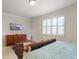 Bright main bedroom with a TV, a coffee table, and a window with plantation shutters at 9761 Sw 74Th Pl, Ocala, FL 34481