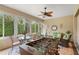 Relaxing sunroom with a ceiling fan, comfortable seating, and views of the lush landscaping at 9761 Sw 74Th Pl, Ocala, FL 34481