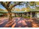 Spacious backyard deck, shaded by a mature tree, enhances the outdoor living space at 4942 Cr 300, Lake Panasoffkee, FL 33538