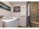 Bathroom featuring neutral color palette, warm wood cabinets, in-unit laundry and modern shower at 4942 Cr 300, Lake Panasoffkee, FL 33538