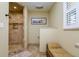 Bright bathroom featuring tiled walk-in shower, neutral paint color and decorative shutters for natural light at 4942 Cr 300, Lake Panasoffkee, FL 33538