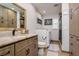 Tastefully designed bathroom featuring warm wood cabinetry and a convenient washer and dryer area at 4942 Cr 300, Lake Panasoffkee, FL 33538
