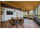 Inviting covered patio featuring a wood ceiling, tile floor, and a dining table with four chairs at 4942 Cr 300, Lake Panasoffkee, FL 33538