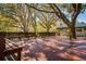 Expansive deck shaded by mature trees, complete with built-in benches, offering a serene outdoor space at 4942 Cr 300, Lake Panasoffkee, FL 33538