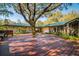 Large deck encircling a tree, integrating the home with the surrounding nature creating a serene outdoor living space at 4942 Cr 300, Lake Panasoffkee, FL 33538