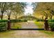 Elegant wrought iron gate leads to a private property lined with trees at 4942 Cr 300, Lake Panasoffkee, FL 33538