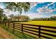 Lush green pasture bordered by a charming brown fence and mature trees at 4942 Cr 300, Lake Panasoffkee, FL 33538