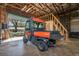 Garage interior showcasing a Kubota utility vehicle and a convenient staircase at 4942 Cr 300, Lake Panasoffkee, FL 33538