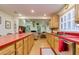 Galley-style kitchen with red countertops, wood cabinets, and an open view to the living room at 4942 Cr 300, Lake Panasoffkee, FL 33538