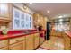 Well-lit kitchen with stainless steel appliances, red countertops and wooden cabinets at 4942 Cr 300, Lake Panasoffkee, FL 33538