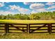 Spacious paddock area enclosed by a wooden fence, with lush greenery, and a view of the property at 4942 Cr 300, Lake Panasoffkee, FL 33538