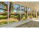 Screened-in porch with view of mature trees, manicured lawns, and outbuilding at 4942 Cr 300, Lake Panasoffkee, FL 33538