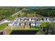 Aerial view showcasing a modern residential neighborhood with uniform homes and tidy lawns by a pond at 2244 Teneroc Trl, Lakeland, FL 33805