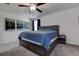 Bright bedroom featuring a ceiling fan, a comfortable bed with blue quilt, and landscape artwork on the wall at 2244 Teneroc Trl, Lakeland, FL 33805