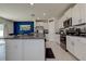 This spacious kitchen showcases a granite island, white cabinets and stainless steel appliances with a view to the backyard at 2244 Teneroc Trl, Lakeland, FL 33805