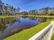 A serene pond reflects the surrounding trees and sky, adding to the beauty and tranquility of the property at 2244 Teneroc Trl, Lakeland, FL 33805