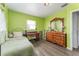 Bright bedroom with a wood floor, desk, and a light green wall at 520 S Orange Ave, Fort Meade, FL 33841