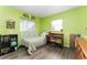 A vibrant bedroom with a single bed, desk, wood floors, and green walls at 520 S Orange Ave, Fort Meade, FL 33841