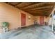 Side view of the home featuring block construction, red doors, concrete flooring and wood beams above at 520 S Orange Ave, Fort Meade, FL 33841