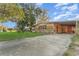 Inviting single-story home with a large driveway, mature trees, and a covered carport at 520 S Orange Ave, Fort Meade, FL 33841
