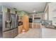 Traditional kitchen with stainless steel refrigerator, cabinets, and white tile flooring at 520 S Orange Ave, Fort Meade, FL 33841