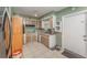 Cozy kitchen with brown cabinets, white tile flooring, and a white door at 520 S Orange Ave, Fort Meade, FL 33841