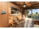 Enclosed patio featuring comfortable seating, concrete flooring, and a modern leaf-shaped ceiling fan at 520 S Orange Ave, Fort Meade, FL 33841