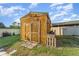 Wooden shed with double doors, surrounded by a green lawn and a partial white fence at 520 S Orange Ave, Fort Meade, FL 33841