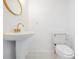 Stylish powder room features a unique pedestal sink, gold hardware, and a classic toilet at 407 W Oak Dr, Lakeland, FL 33803