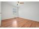 Bright bedroom features wood floors, a ceiling fan, a window, and neutral paint throughout at 407 W Oak Dr, Lakeland, FL 33803