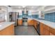Bright kitchen with stainless steel appliances, an island, and modern blue backsplash at 407 W Oak Dr, Lakeland, FL 33803