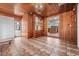 Warm and inviting living space featuring wooden walls and a tile floor that leads to the kitchen at 407 W Oak Dr, Lakeland, FL 33803