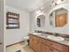 Bathroom with double sink vanity, tile floor, and framed mirrors with modern lighting at 4845 Sw 78Th Ave, Bushnell, FL 33513