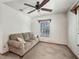 Cozy bedroom features a comfortable couch, ceiling fan, and natural light from the window at 4845 Sw 78Th Ave, Bushnell, FL 33513