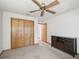 Bright bedroom with ceiling fan, neutral carpet, closet, and dark wood media cabinet at 4845 Sw 78Th Ave, Bushnell, FL 33513