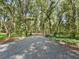 Long gravel driveway leading through a lush, green, treed property at 4845 Sw 78Th Ave, Bushnell, FL 33513