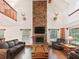 Stunning living room with high ceilings, stone fireplace, wood floors, and large windows at 4845 Sw 78Th Ave, Bushnell, FL 33513