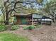 A quaint outdoor structure featuring a picnic table, grill area, and rustic charm amidst lush greenery at 4845 Sw 78Th Ave, Bushnell, FL 33513