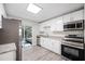 Modern kitchen featuring stainless steel appliances, white cabinetry, and granite countertops at 1126 Waterview E Blvd, Lakeland, FL 33801