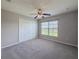 Bedroom with ceiling fan, window with a view and a closet with white doors at 5335 River Rock Rd, Lakeland, FL 33809