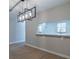 Close up of the dining room with a modern light fixture and passthrough to the kitchen at 5335 River Rock Rd, Lakeland, FL 33809