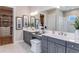 A luxurious bathroom featuring double sinks, vanity, with framed art and with a walk-in closet at 5646 Nevis Ter, Kissimmee, FL 34758