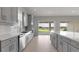 Bright, open kitchen featuring gray cabinets, an island, and views of a lake at 5646 Nevis Ter, Kissimmee, FL 34758